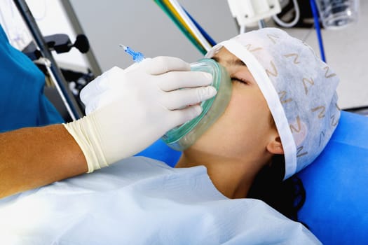 SurgeonŽs hand putting an oxygen mask on a female patient