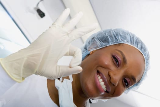 Close-up of a female surgeon smiling and making an OK sign