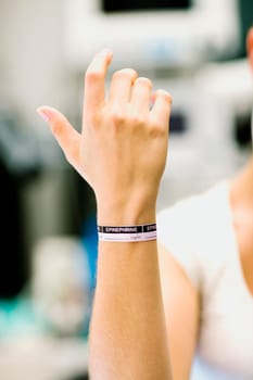 Close-up of a womanŽs hand with dosage tag around her wrist