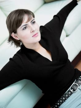 Close-up of a businesswoman leaning against a couch