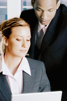 Close-up of a businessman and a businesswoman looking at a laptop