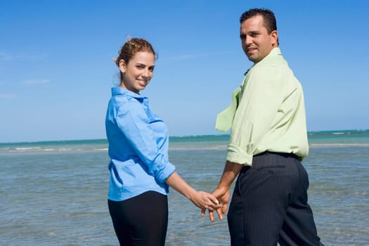 Portrait of a mid adult couple standing on the beach with holding their hands