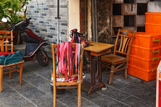 Chair with many multi-colored locks for clothes, street sewing workshop in China, Guilin Aug 24, 2019