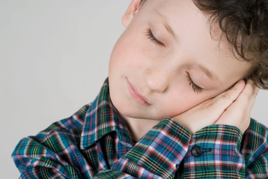 Close_up of a boy resting his face on his hands