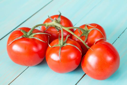 Fresh tomatoes on the vine  on a blue wooden background
