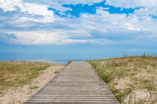 Wooden path over sand dunes with sea view