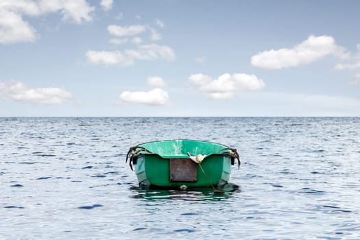 Empty wooden boat floating out to sea
