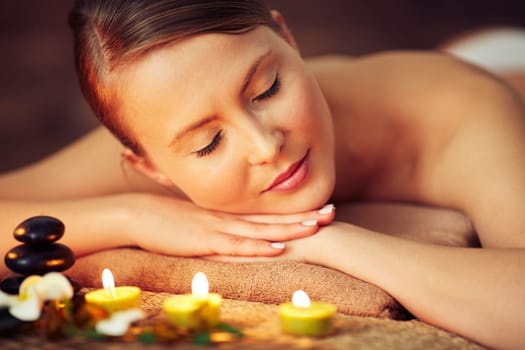 Woman lying on towel at beauty spa