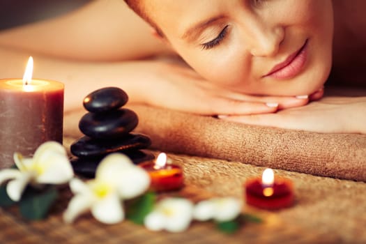 Close-up of female face among candles