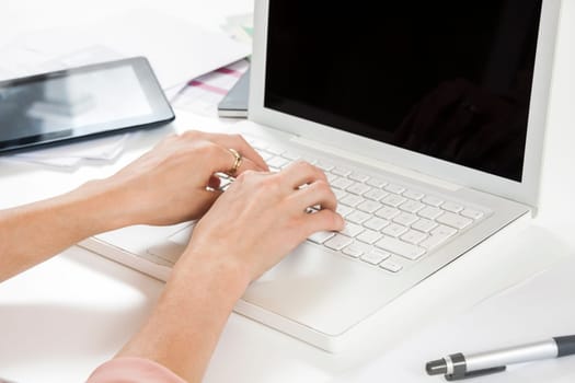 Young businesswoman reads statistics at the desk on the computer with red hair and glasses in the office