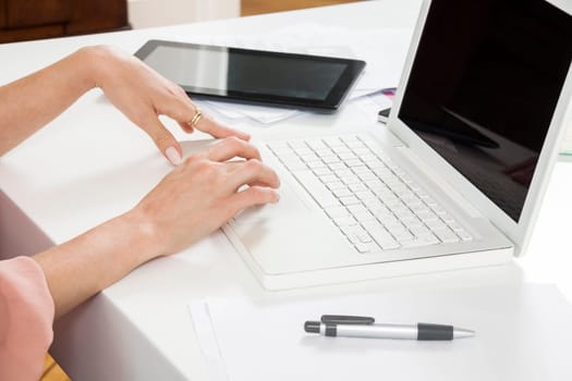 Young businesswoman reads statistics at the desk on the computer with red hair and glasses in the office