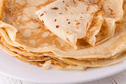 delicious fresh crepes pancakes pancakes on a white plate on a rustic white wooden board