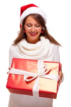 Pretty brunette woman with Christmas hat and big red gift cheerfullaughing isolated against white background
