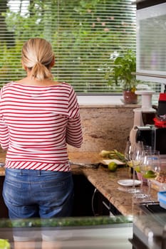 attractive blonde woman prepares meat for barbecue in the kitchen
