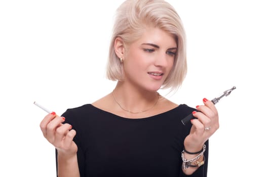 Young blonde woman smoker chooses between e-cigarette and cigarette isolated against white background