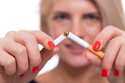 Young blonde woman breaks a cigarette stops smoking isolated against white background
