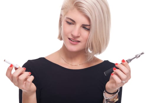 Young blonde woman smoker chooses between e-cigarette and cigarette isolated against white background