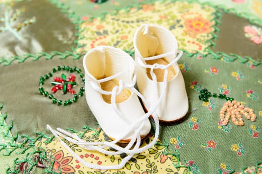 pair of doll shoes on green patchwork
