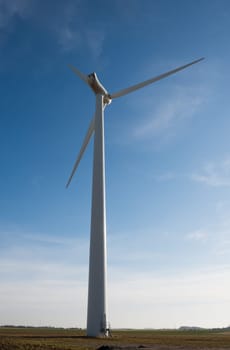 wind turbine on a blue sky with a few clouds