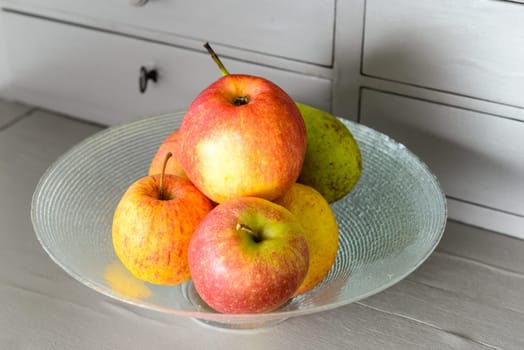 glass cup with red and yellow apples