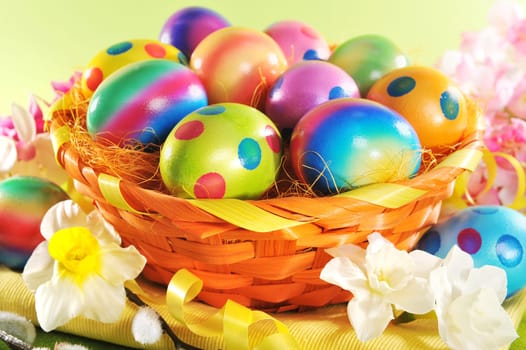 Colourful Easter basket with painted Easter eggs,daffodils and palm kittens