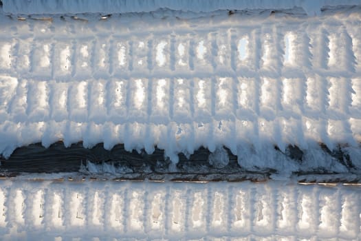 A close up of a fence with snow frozen