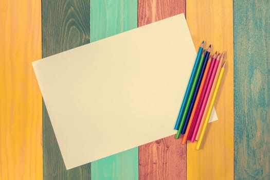 Blank paper and colorful pencils on the color table. View from above