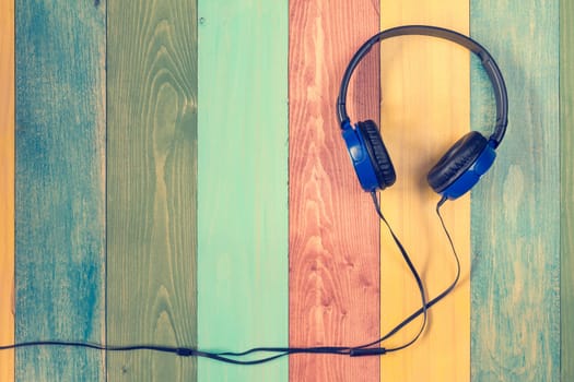 Headphones on colored wooden background with copy-space