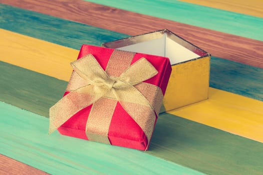 Open gift box on color wooden background.Copy-space.