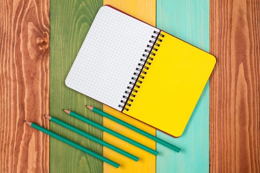 Personal organizer and four pencil on color background.Copy-space for your text.