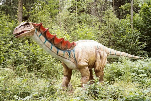 Gigantic statue of realistic dinosaur in a forest