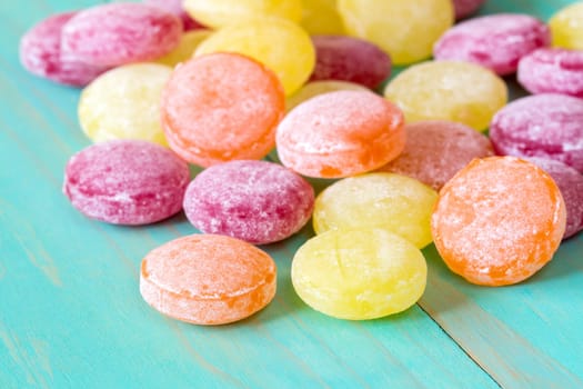 Multi colored candy on blue wooden background,close up view