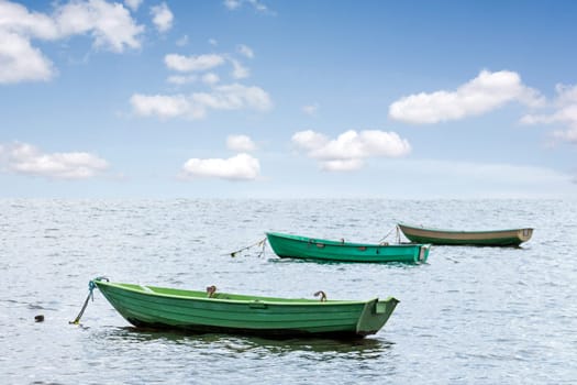 Three wooden boats floating out to sea