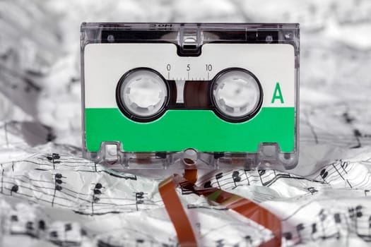 Audio cassette on the crumpled music sheet