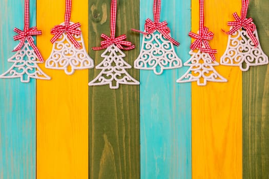 Christmas baubles and glittery xmas over colored wooden background