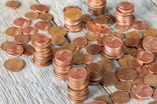 Euro cents stacked on wooden background. Concept for financial savings.