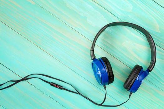 Headphones on wooden background with copy-space