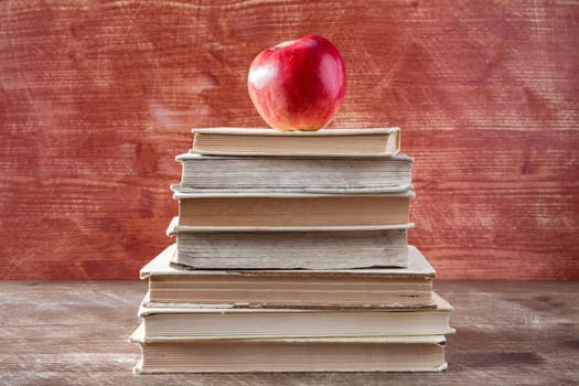 Books pyramid with red apple. Education concept.