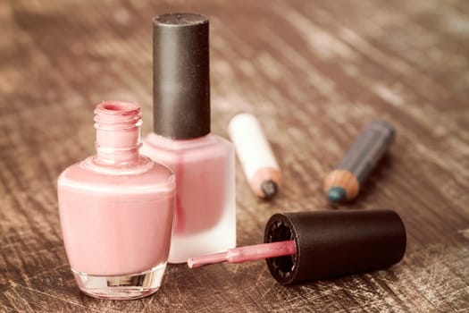 Nail polish and eye pencils on a wooden table