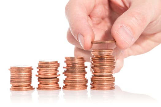 Hand put coin to money staircase isolated on white background