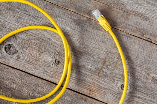 Yellow internet cable on the old wooden background