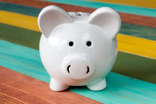 Piggy bank on color wooden background, close-up view