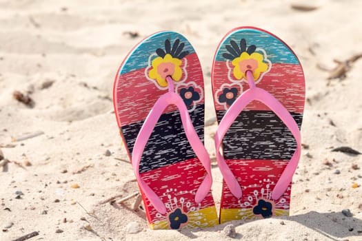 Sandal flip flop on the white sand beach in summer vacations