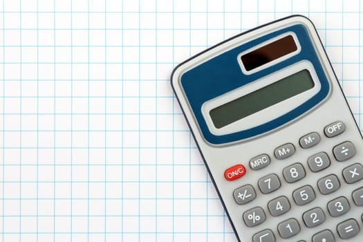 Electronic digital calculator on squared paper background