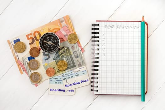 Business travel and tourism concept: air tickets or boarding pass,money,compass and traveler's notebook for trip planning