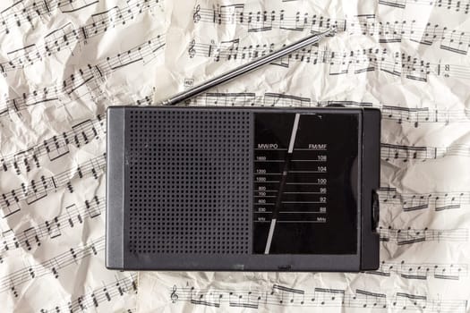 Old scratched radio receiver on the crumpled notes background