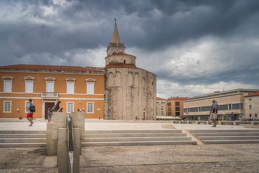 Zadar, Croatia, July 2019 Tourists sightseeing a St. Donata, circular church in early Romanesque architecture style on Pope John Paul II square
