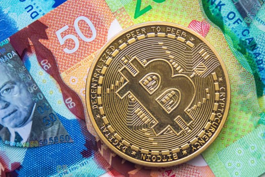 Calgary, Alberta. Canada. Jan 29, 2021. A Bitcoin coin with Canadian currency on the background