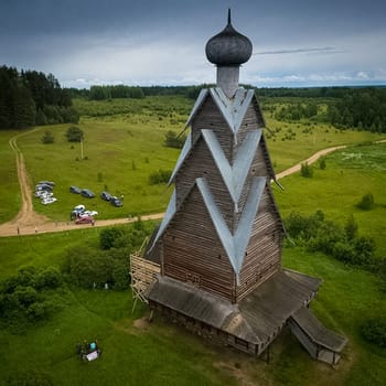 A wooden church in the summer on the edge of the forest.