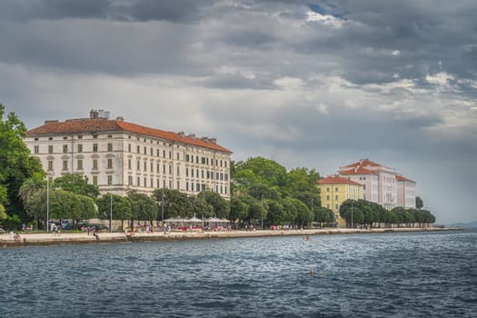 Zadar, Croatia, July 2019 Crowds of tourists walking and relaxing on the Coast of King Petar Kresimir IV, with a view on University of Zadar